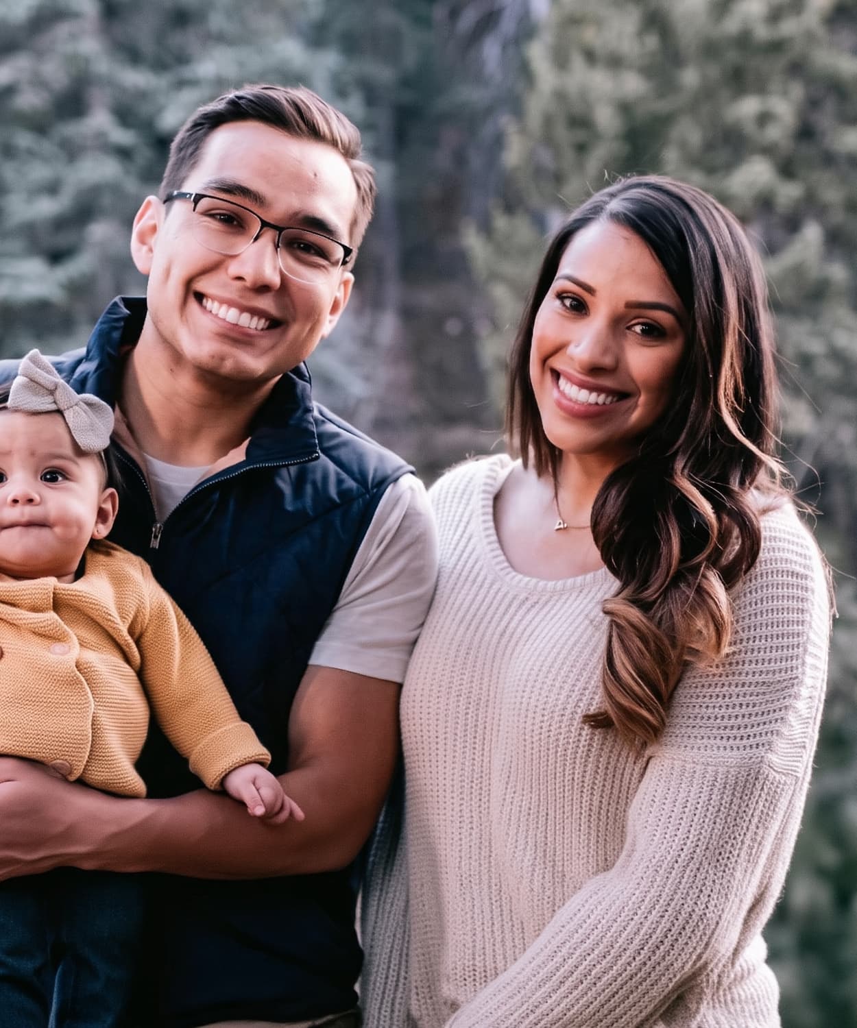 Astrid Cabas with her husband and daughter outdoors in a forest setting